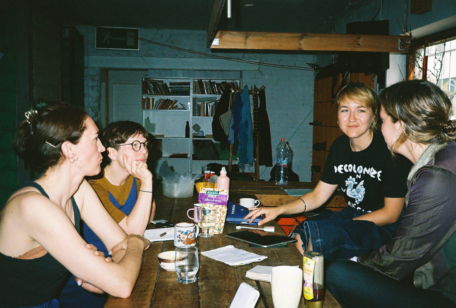A color photo of four persons, including Samantha Lippett and Ieva Gudaitylė, sitting at a table for an ICRN meeting. Three of them look at the fourth who is speaking.